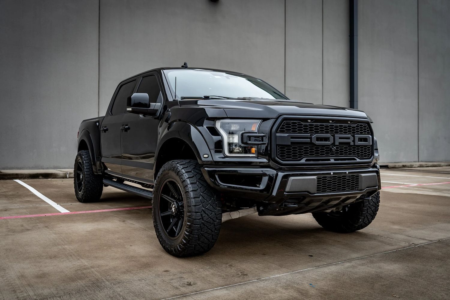 Blacked out Ford F-150 Raptor with fender flares and offroad tires