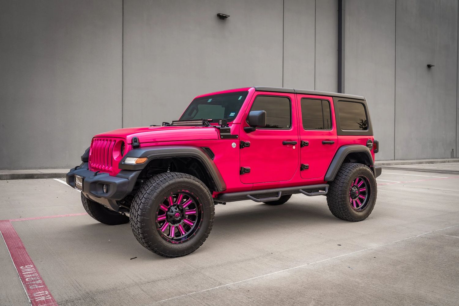 Pink Jeep Wrangler Unlimited on matching pink and black wheels